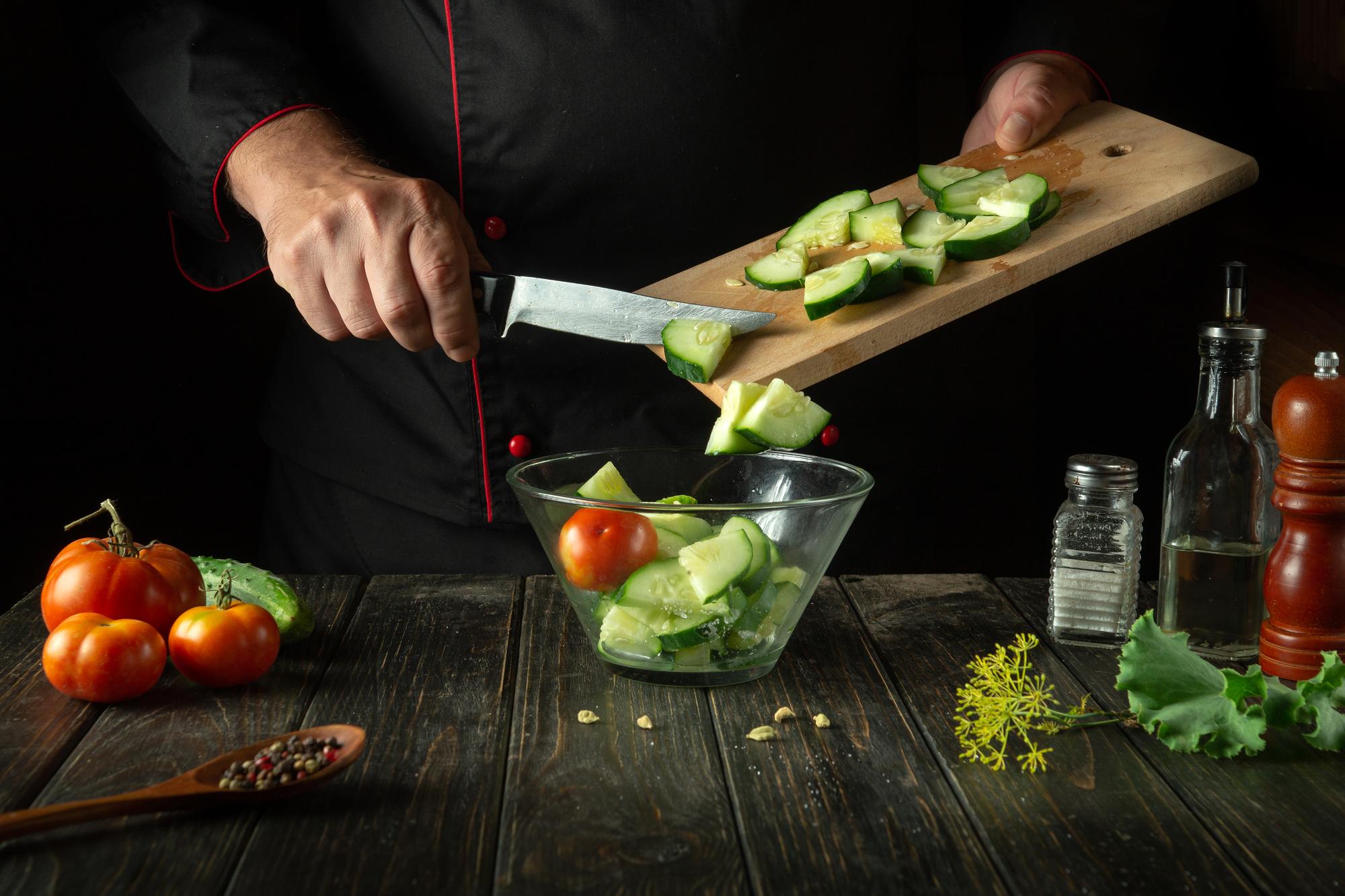 Chef che affetta verdure in cucina professionale
